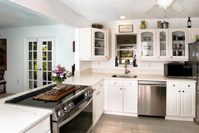 6504 Heritage Ln Unit 99, Bradenton, FL 34209 - kitchen with appliances with stainless steel finishes, white cabinetry, glass insert cabinets, and a ceiling fan
