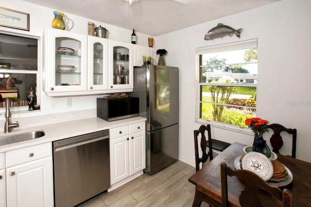 6504 Heritage Ln Unit 99, Bradenton, FL 34209 - kitchen featuring stainless steel dishwasher, black microwave, freestanding refrigerator, light countertops, and white cabinets