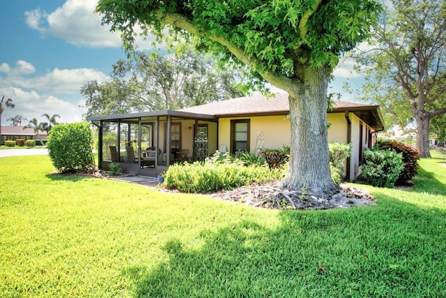 6504 Heritage Ln Unit 99, Bradenton, FL 34209 - rear view of property featuring a sunroom, a lawn, and stucco siding