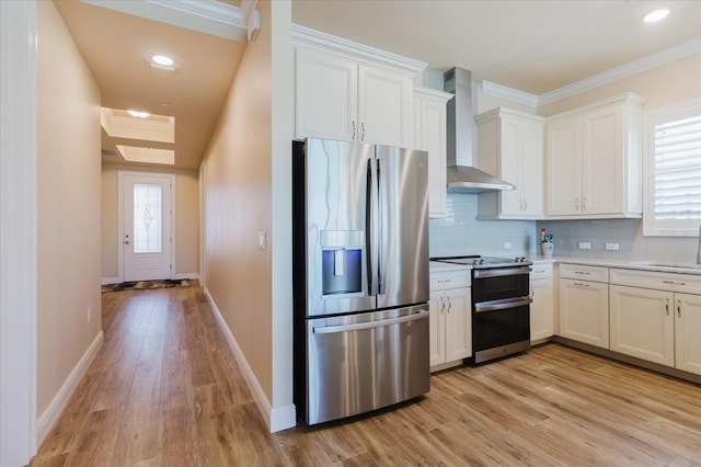 501 Tamiami Trl N Unit 201, Venice, FL 34285 - kitchen featuring stainless steel appliances, wall chimney range hood, light wood-type flooring, crown molding, and light countertops