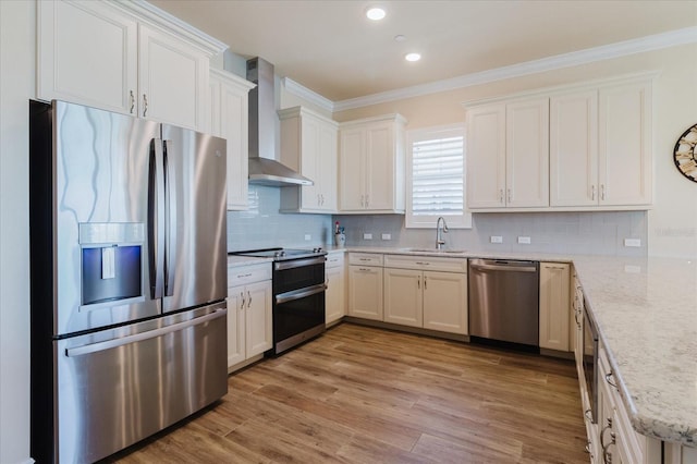 501 Tamiami Trl N Unit 201, Venice, FL 34285 - kitchen featuring stainless steel appliances, wall chimney range hood, ornamental molding, light wood-style floors, and decorative backsplash