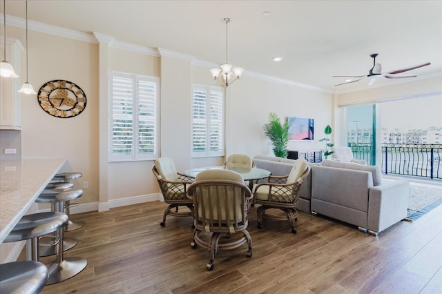 501 Tamiami Trl N Unit 201, Venice, FL 34285 - dining area with healthy amount of natural light, wood finished floors, ornamental molding, a ceiling fan, and a chandelier