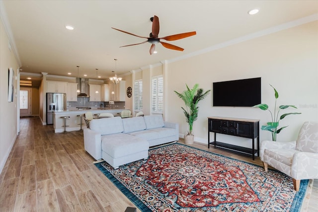 501 Tamiami Trl N Unit 201, Venice, FL 34285 - living room with crown molding, a ceiling fan, recessed lighting, light wood-style floors, and a chandelier