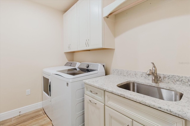 501 Tamiami Trl N Unit 201, Venice, FL 34285 - washroom featuring separate washer and dryer, cabinet space, and light wood finished floors