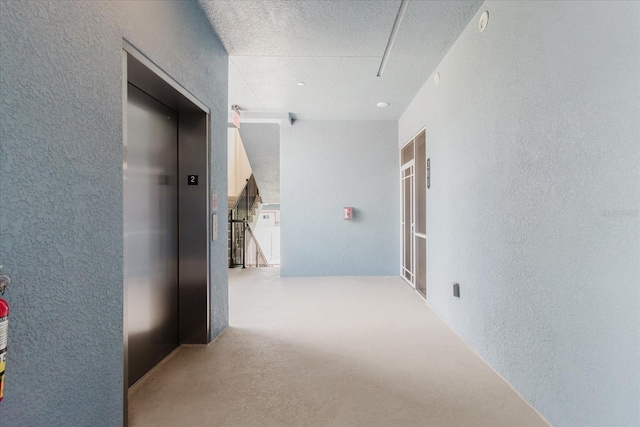 501 Tamiami Trl N Unit 201, Venice, FL 34285 - hall with a textured wall, elevator, a textured ceiling, and attic access