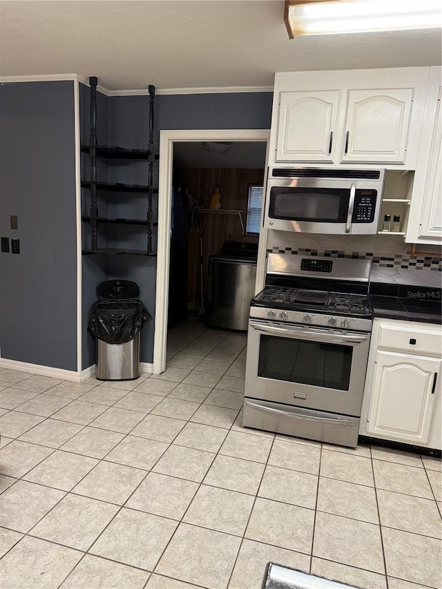 1123 NW 192nd Ave, Gainesville, FL 32609 - kitchen featuring appliances with stainless steel finishes, dark countertops, white cabinetry, and light tile patterned floors