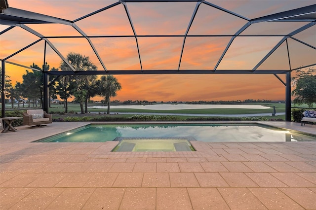 3968 Santa Caterina Blvd, Bradenton, FL 34211 - pool at dusk with a patio area, glass enclosure, and a pool with connected hot tub