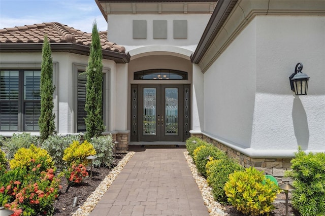 3968 Santa Caterina Blvd, Bradenton, FL 34211 - doorway to property featuring french doors, stone siding, and stucco siding