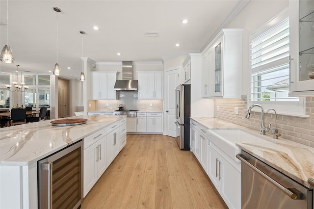 3968 Santa Caterina Blvd, Bradenton, FL 34211 - kitchen featuring wine cooler, wall chimney exhaust hood, stainless steel appliances, ornamental molding, and white cabinetry