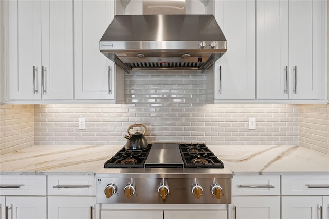 3968 Santa Caterina Blvd, Bradenton, FL 34211 - kitchen with wall chimney range hood, stainless steel gas stovetop, tasteful backsplash, and white cabinetry