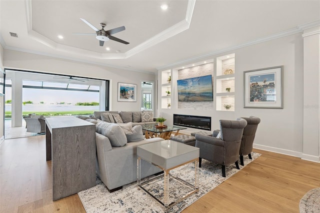 3968 Santa Caterina Blvd, Bradenton, FL 34211 - living area with a ceiling fan, light wood-style floors, a tray ceiling, built in features, and crown molding