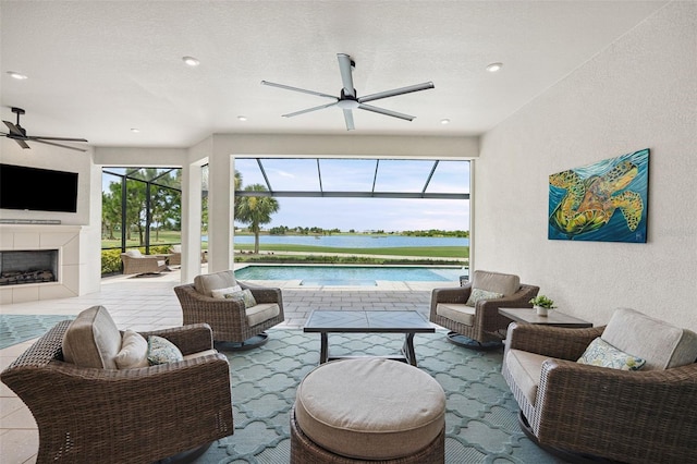 3968 Santa Caterina Blvd, Bradenton, FL 34211 - living room with ceiling fan, plenty of natural light, a textured wall, a water view, and a fireplace