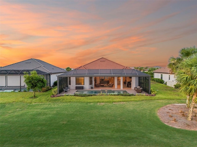 3968 Santa Caterina Blvd, Bradenton, FL 34211 - back of house at dusk featuring a patio area, a tiled roof, a yard, and an outdoor pool