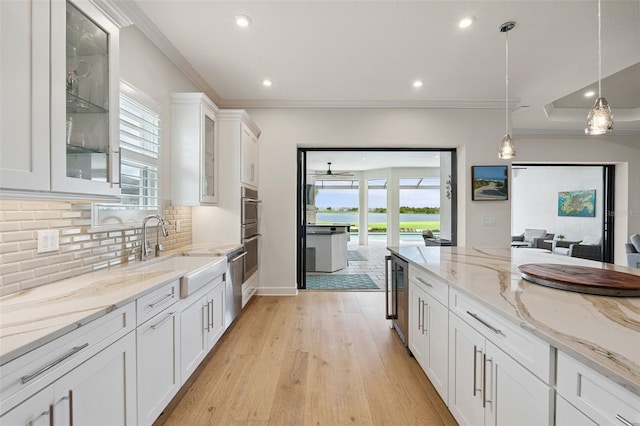 3968 Santa Caterina Blvd, Bradenton, FL 34211 - kitchen with healthy amount of natural light, white cabinets, recessed lighting, decorative backsplash, and wine cooler