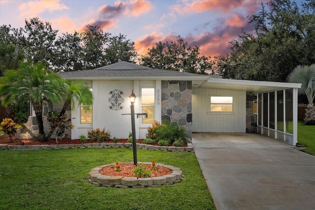 4309 Chinaberry Cir, Bradenton, FL 34208 - view of front of home featuring a yard, concrete driveway, stone siding, and roof with shingles