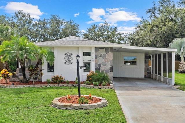 4309 Chinaberry Cir, Bradenton, FL 34208 - view of front of home with driveway, a front yard, a carport, and stone siding
