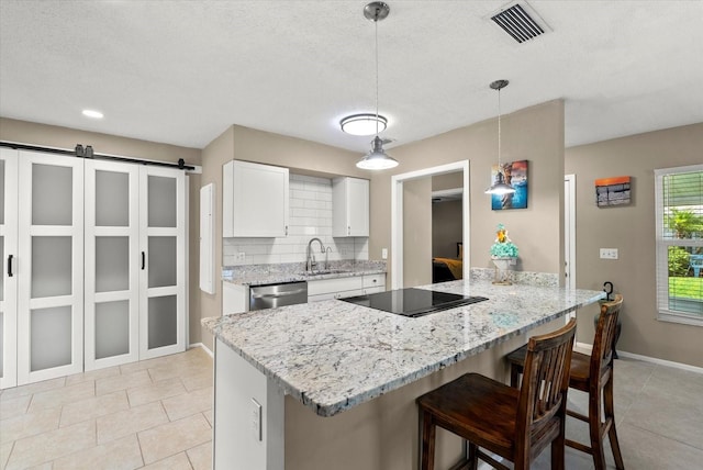 4309 Chinaberry Cir, Bradenton, FL 34208 - kitchen with light tile patterned floors, a breakfast bar area, a peninsula, black electric stovetop, and white cabinets