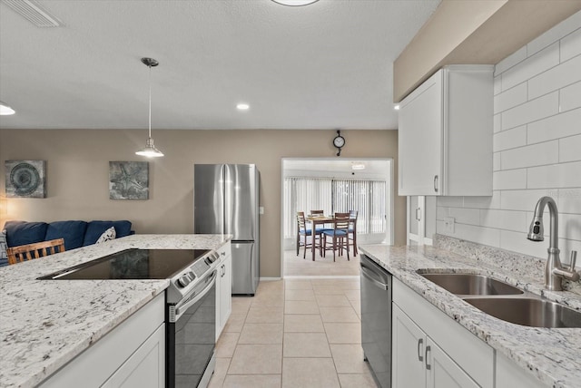 4309 Chinaberry Cir, Bradenton, FL 34208 - kitchen with appliances with stainless steel finishes, white cabinetry, decorative light fixtures, and backsplash