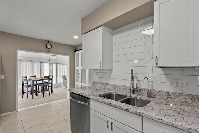 4309 Chinaberry Cir, Bradenton, FL 34208 - kitchen with stainless steel dishwasher, white cabinetry, light stone countertops, decorative backsplash, and recessed lighting