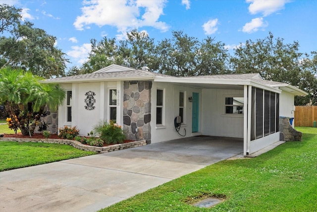 4309 Chinaberry Cir, Bradenton, FL 34208 - view of front of home with driveway, a front lawn, an attached carport, stone siding, and a shingled roof
