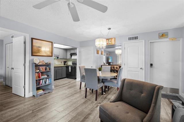 6310 Midnight Pass Rd Unit 405N, Sarasota, FL 34242 - dining room featuring a chandelier, light wood-style flooring, ceiling fan, and a textured ceiling