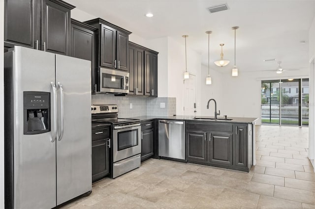6454 Baytown Dr, Sarasota, FL 34240 - kitchen featuring appliances with stainless steel finishes, a peninsula, decorative backsplash, ceiling fan, and dark cabinets