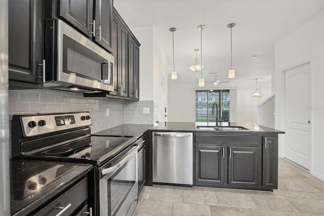 6454 Baytown Dr, Sarasota, FL 34240 - kitchen featuring appliances with stainless steel finishes, backsplash, dark stone countertops, a peninsula, and dark cabinets