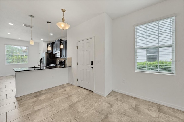 6454 Baytown Dr, Sarasota, FL 34240 - kitchen featuring appliances with stainless steel finishes, dark countertops, a peninsula, hanging light fixtures, and recessed lighting