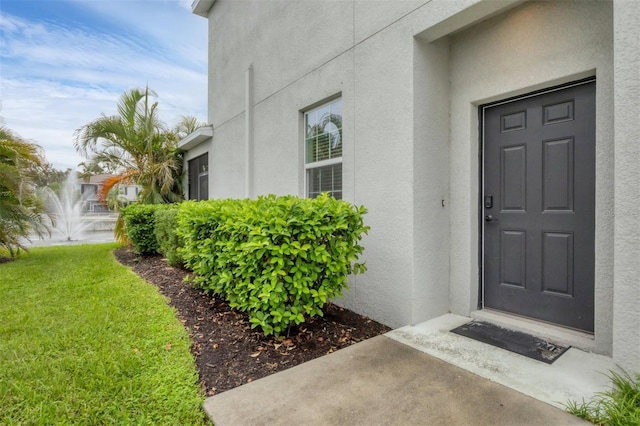 6454 Baytown Dr, Sarasota, FL 34240 - doorway to property featuring stucco siding and a yard