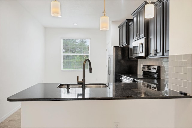 6454 Baytown Dr, Sarasota, FL 34240 - kitchen featuring stainless steel appliances, dark stone countertops, decorative backsplash, pendant lighting, and dark cabinetry