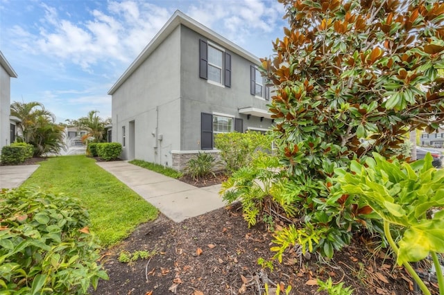 6454 Baytown Dr, Sarasota, FL 34240 - view of home's exterior featuring stucco siding, a lawn, and stone siding