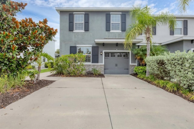 6454 Baytown Dr, Sarasota, FL 34240 - view of front of home with stucco siding, stone siding, concrete driveway, and an attached garage