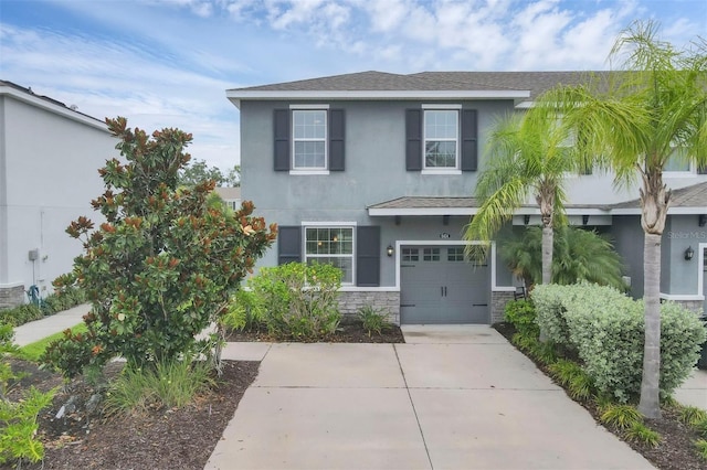 6454 Baytown Dr, Sarasota, FL 34240 - view of front of house with stucco siding, concrete driveway, stone siding, and roof with shingles