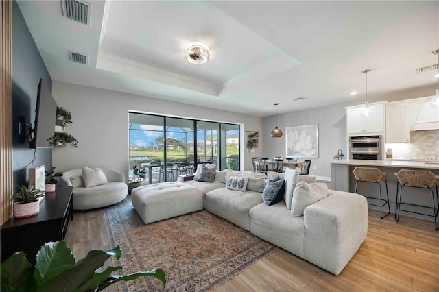 16418 Slate Pl, Lakewood Ranch, FL 34211 - living area featuring light wood-style flooring, a tray ceiling, crown molding, and recessed lighting