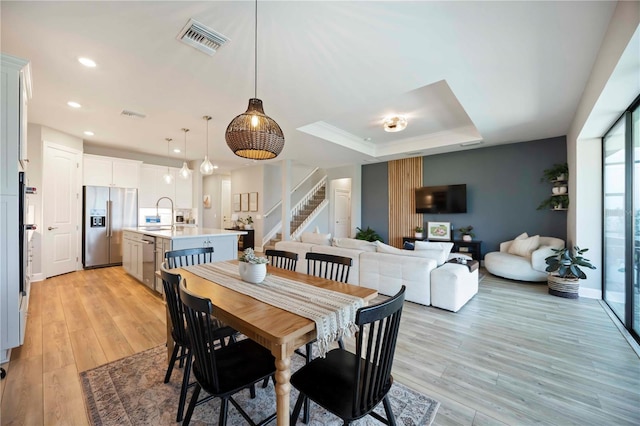 16418 Slate Pl, Lakewood Ranch, FL 34211 - dining space featuring stairs, light wood-style flooring, a raised ceiling, and recessed lighting