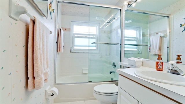 5078 47th St W, Bradenton, FL 34210 - bathroom with vanity, bath / shower combo with glass door, healthy amount of natural light, and wallpapered walls