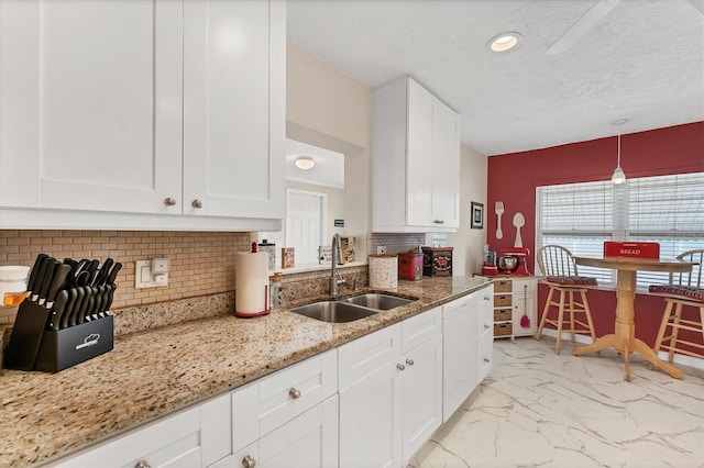 401 N Jefferson Ave, Sarasota, FL 34237 - kitchen featuring white dishwasher, light marble finish flooring, white cabinets, tasteful backsplash, and light stone counters