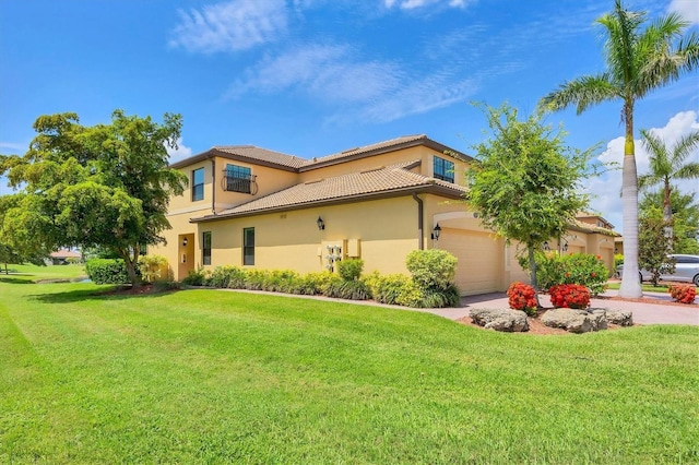 6512 Grand Estuary Trl Unit 101, Bradenton, FL 34212 - view of front facade with a front yard, a tile roof, stucco siding, and driveway