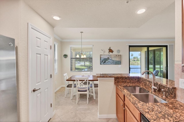 6512 Grand Estuary Trl Unit 101, Bradenton, FL 34212 - kitchen featuring freestanding refrigerator, ornamental molding, dark stone counters, healthy amount of natural light, and light tile patterned floors