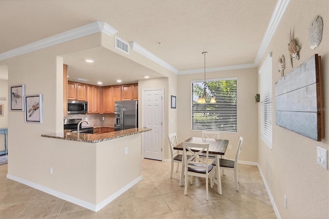 6512 Grand Estuary Trl Unit 101, Bradenton, FL 34212 - kitchen featuring stainless steel appliances, dark stone countertops, crown molding, backsplash, and light tile patterned flooring