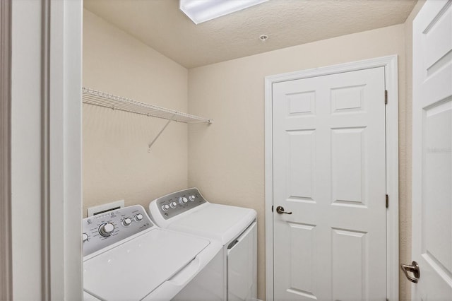 6512 Grand Estuary Trl Unit 101, Bradenton, FL 34212 - washroom featuring washing machine and clothes dryer and a textured ceiling