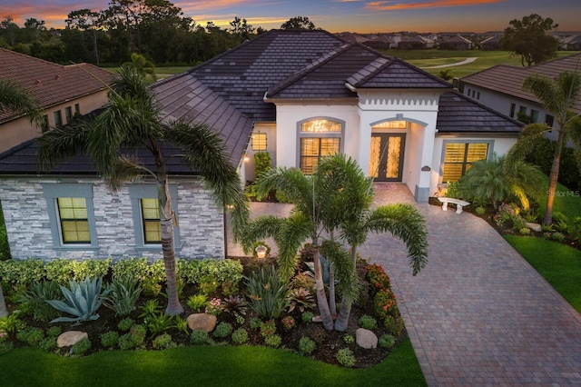 5804 Mulligan Way, Lakewood Ranch, FL 34211 - view of front of house with french doors, stucco siding, stone siding, and a tile roof