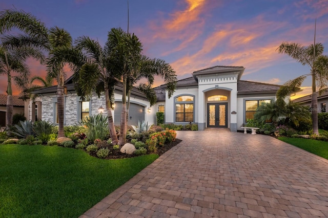 5804 Mulligan Way, Lakewood Ranch, FL 34211 - mediterranean / spanish-style home featuring french doors, decorative driveway, a yard, an attached garage, and stucco siding