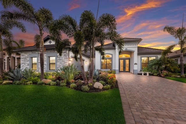 5804 Mulligan Way, Lakewood Ranch, FL 34211 - mediterranean / spanish-style home featuring french doors, a yard, stone siding, and driveway