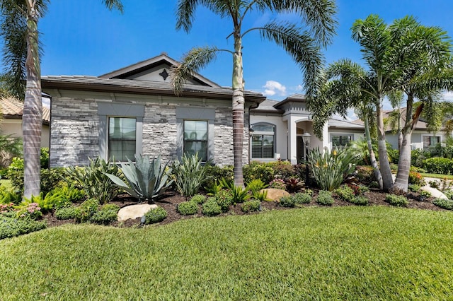 5804 Mulligan Way, Lakewood Ranch, FL 34211 - view of front of house with stone siding, a front yard, and stucco siding