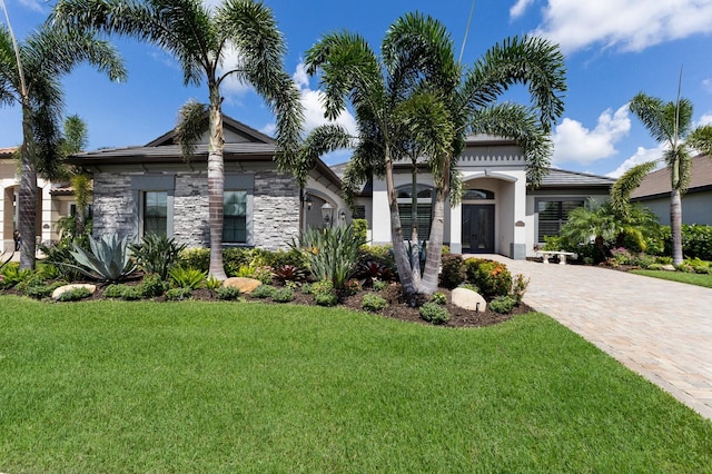 5804 Mulligan Way, Lakewood Ranch, FL 34211 - view of front of property with a front yard, driveway, stone siding, and stucco siding