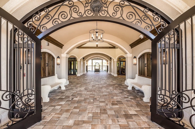 5804 Mulligan Way, Lakewood Ranch, FL 34211 - foyer featuring arched walkways, stone tile flooring, a chandelier, ornamental molding, and vaulted ceiling