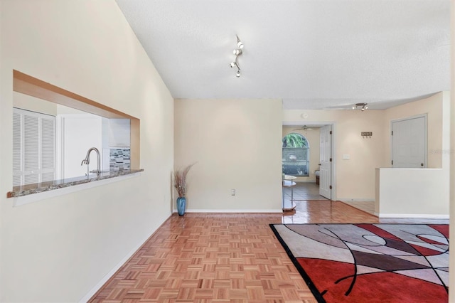 4107 Brittany Ln Unit 18, Sarasota, FL 34233 - unfurnished living room featuring a textured ceiling and rail lighting