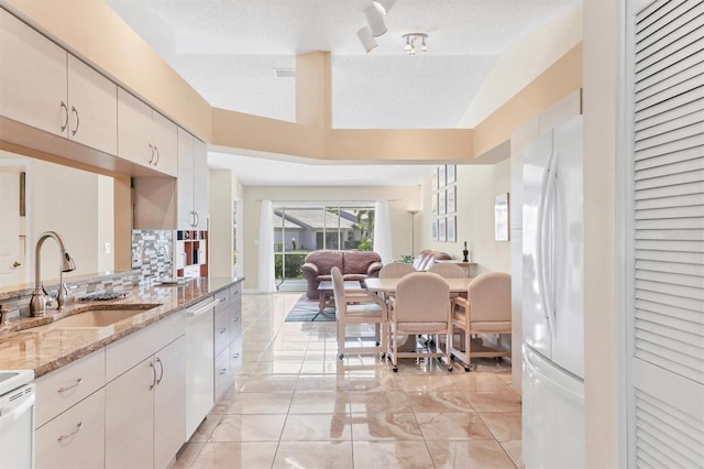 4107 Brittany Ln Unit 18, Sarasota, FL 34233 - kitchen featuring freestanding refrigerator, dishwasher, open floor plan, backsplash, and light stone counters