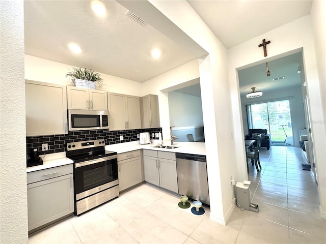6253 Whetstone Ct, Palmetto, FL 34221 - kitchen with stainless steel appliances, gray cabinets, decorative backsplash, light countertops, and recessed lighting
